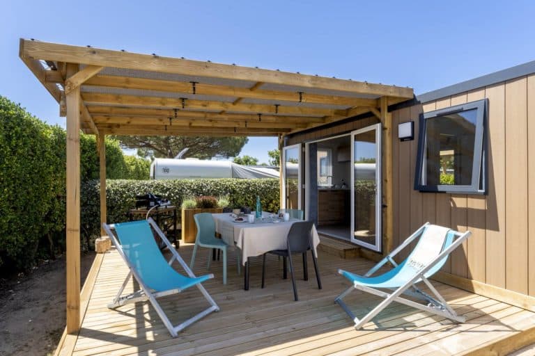 Terrasse de mobil-home moderne avec chaises longues bleues.