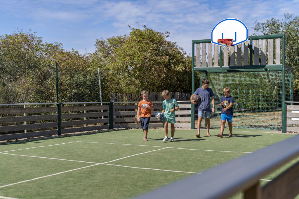 4 jeunes sur un terrain de foot 