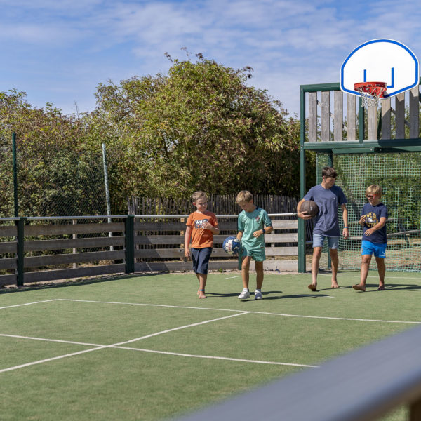 4 jeunes sur un terrain de foot