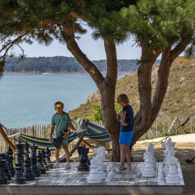 Deux jeunes garçons qui joue au échecs géants