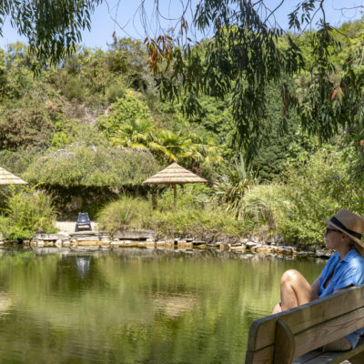 Vrouw zittend aan de rand van een vijver