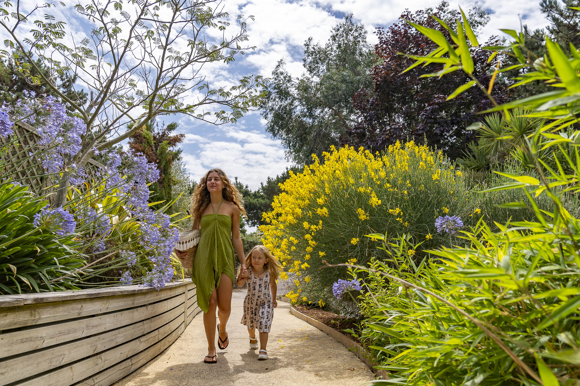 Femme et sa fille qui se balade dans un chemin fleuri