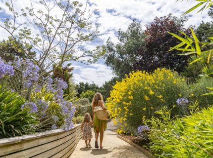 Vrouw en haar dochter wandelen over een bloemrijk pad