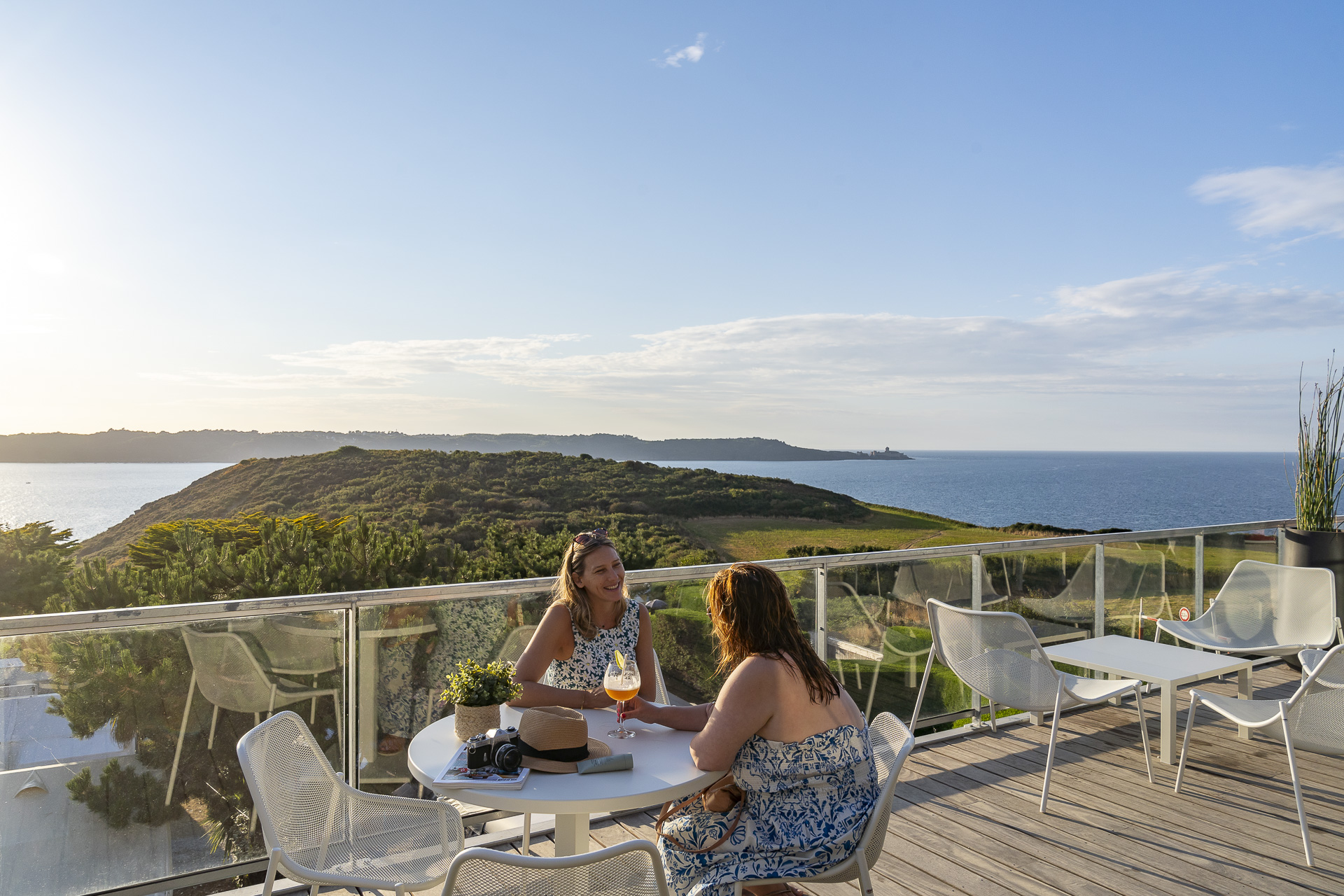 Deux femmes qui discutent à une table surplombant l'océan